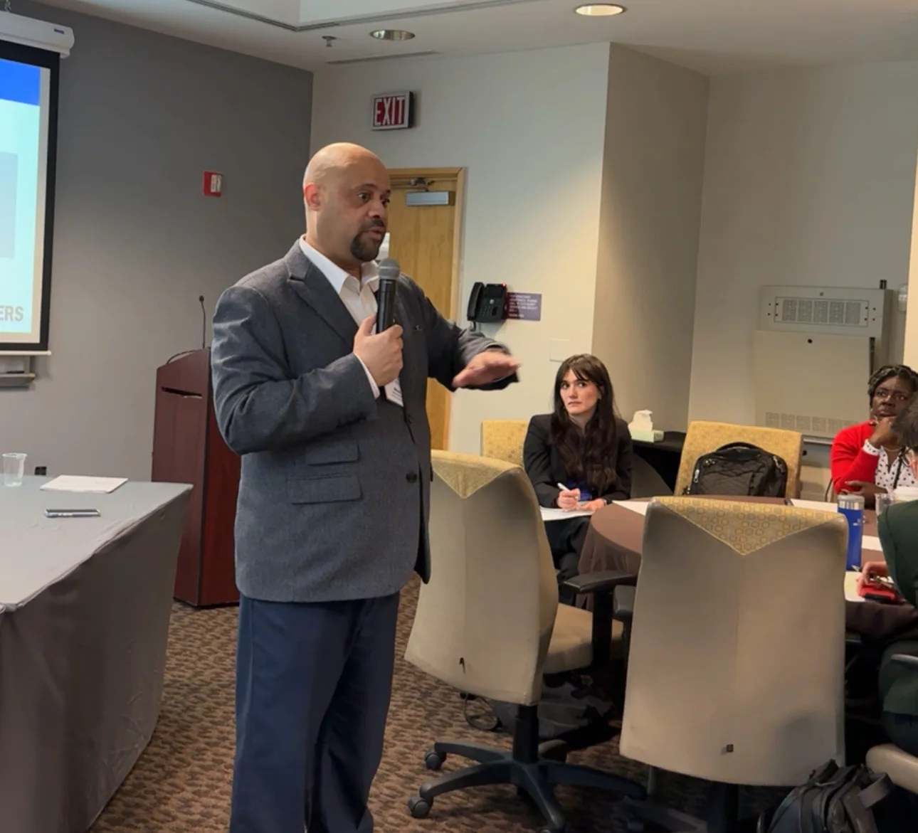 Mike Roberts speaking with participants seated around workshop tables